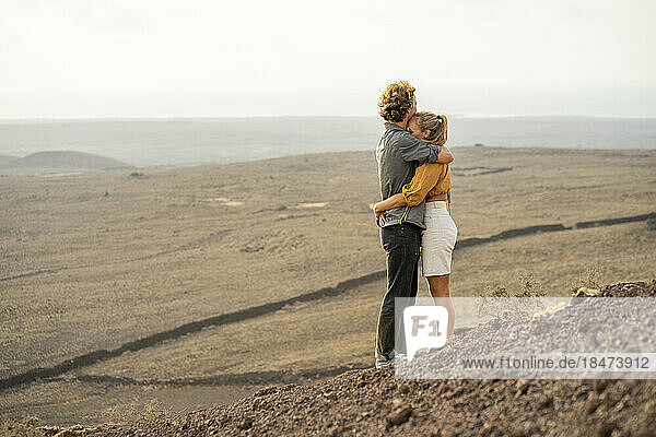 Romantisches junges Paar umarmt sich auf dem Berg