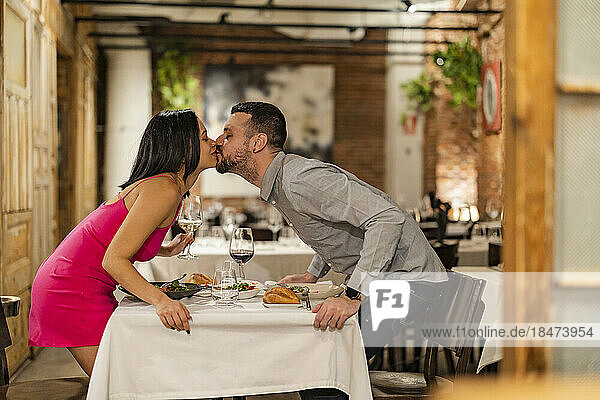 Romantisches Paar küsst sich im Restaurant