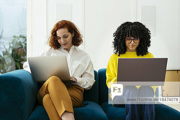 Smiling businesswomen using laptop working in office