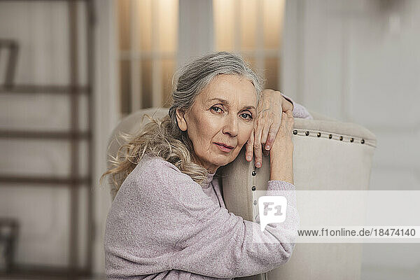 Senior woman sitting on chair at home