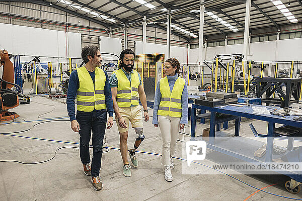 Engineers wearing reflective clothing walking in factory