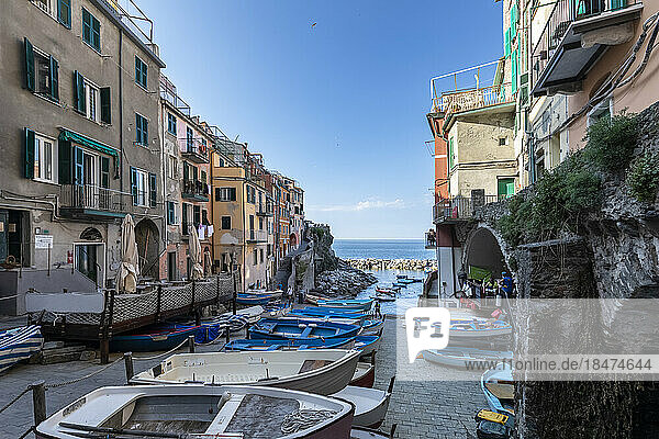 Italy  Liguria  Riomaggiore  Row of boats lying at edge of coastal town along Cinque Terre