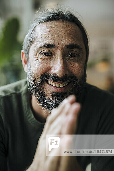 Smiling mature man with beard in cafe