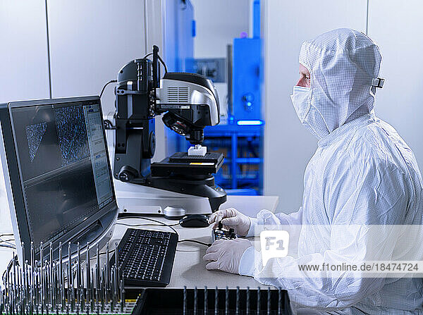 Engineer working on desktop PC in laboratory