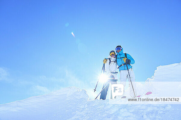 Liebevolles reifes Paar steht an einem sonnigen Tag im Schnee