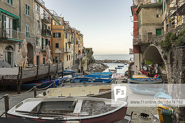 Italy  Liguria  Riomaggiore  Row of boats lying at edge of coastal town along Cinque Terre