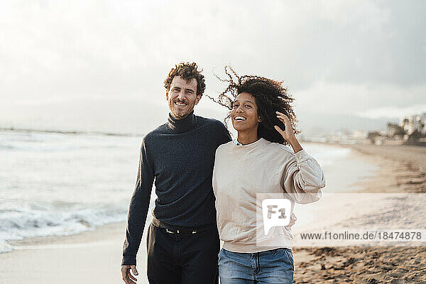 Glücklicher Mann und Frau  die gemeinsam am Strand spazieren gehen