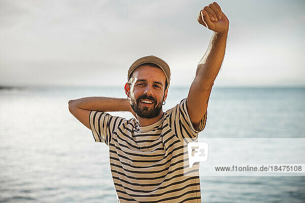 Smiling man with hand raised wearing striped t-shirt