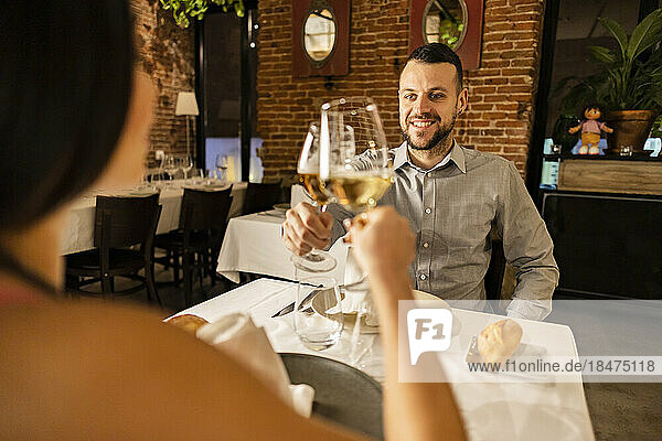 Couple toasting wineglasses in restaurant