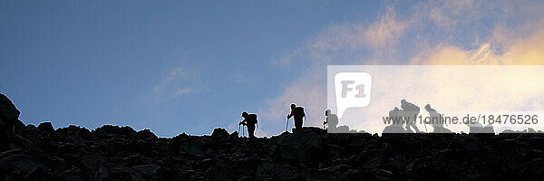 Silhouette friends hiking on Mt Ararat at sunset