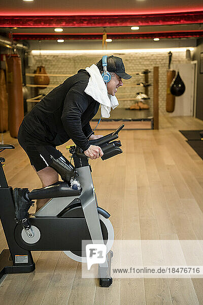 Determinant man with artificial limb working out on exercise bike in gym