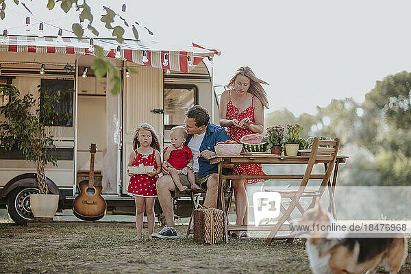 Parents and children prepating picnic camper van