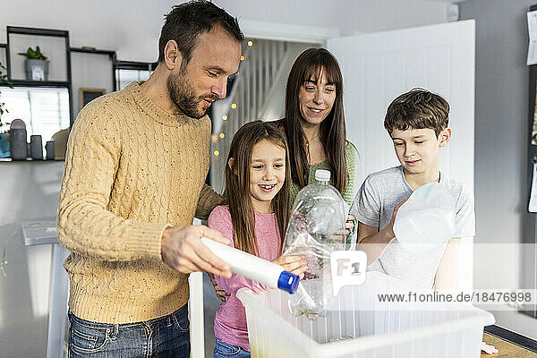 Happy family recycling plastic at home