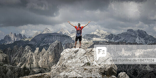 Carefree man standing with arms raised at Langkofel  Dolomites  Italy