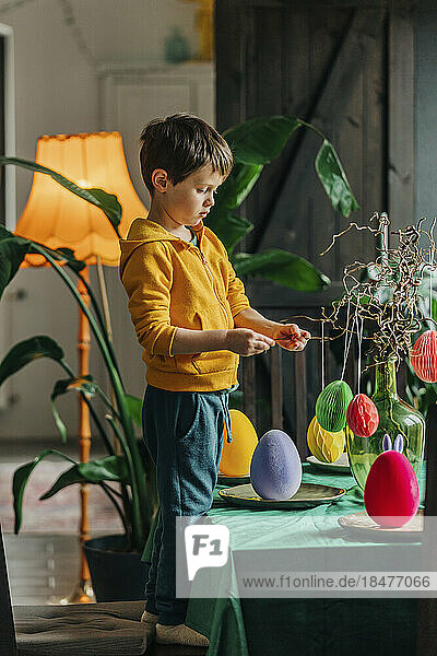 Boy decorating table for Easter dinner at home
