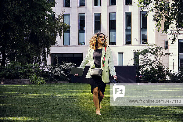 Happy businesswoman walking in office park
