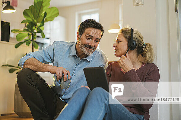 Woman with headset discussing with husband at home office