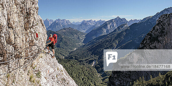 Man rock climbing on sunny day at Dolomiti Bellunesi National Park Forcella Comedon  Dolomites  Italy