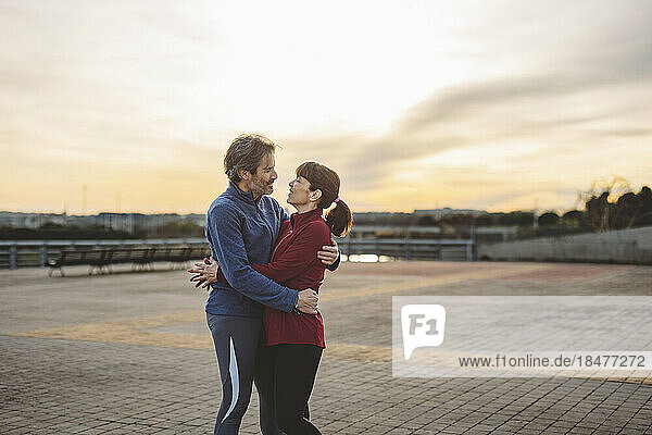 Loving mature couple embracing each other at sunset