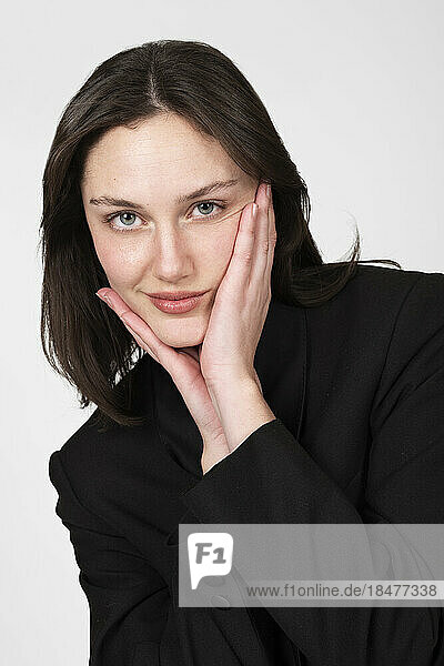 Young woman touching face over white background