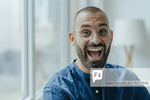 Happy businessman wearing eyeglasses at home office