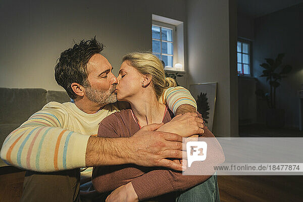 Couple kissing in living room at home