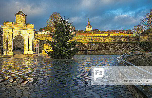 Weilburg Castle with gate and Christmas tree under cloudy sky at sunrise