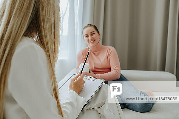 Smiling patient discussing with psychologist in clinic
