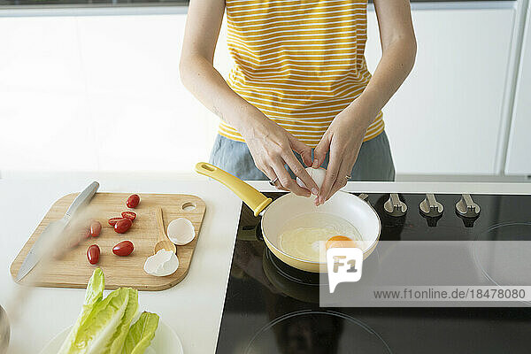 Woman making fried eggs at home
