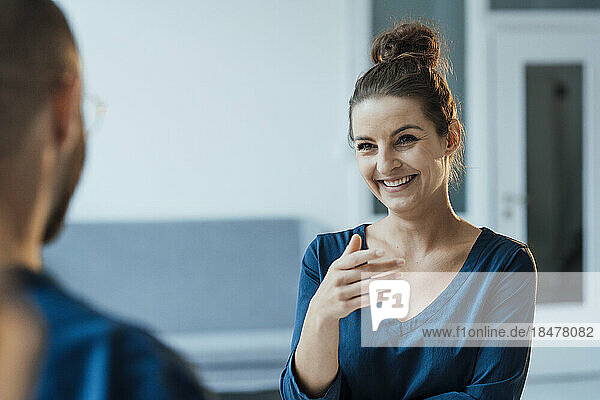 Happy businesswoman talking with colleague at home office