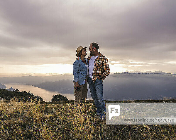 Loving mature couple standing together at sunset