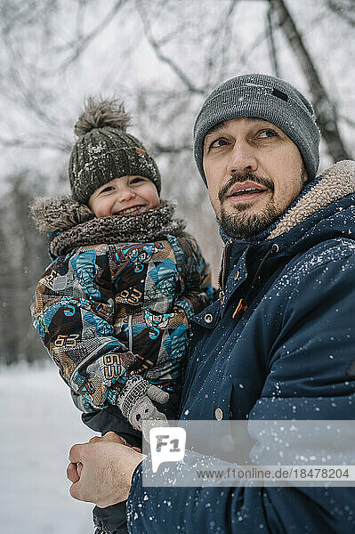 Vater trägt Sohn und hat Spaß im Schnee
