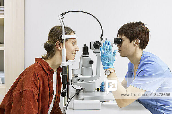 Ophthalmologist conducting vision diagnostics test with patient at clinic