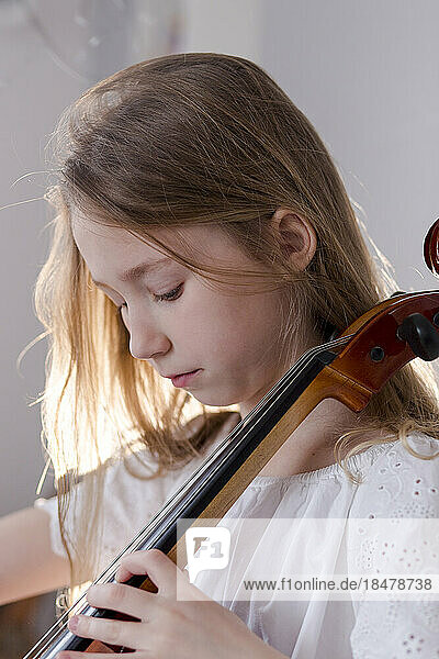 Girl practicing cello at home
