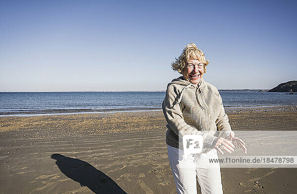 Sorglose Seniorin tanzt und hat Spaß am Strand