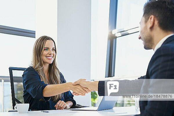 Happy recruiter doing handshake with candidate after job interview at office