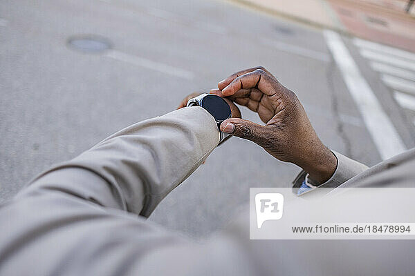 Geschäftsmann überprüft die Zeit auf einer Smartwatch auf der Straße
