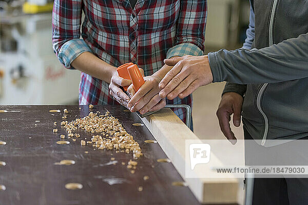 Craftsman assisting trainee in workshop