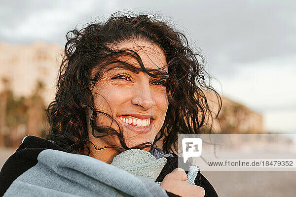 Cheerful thoughtful young woman at beach