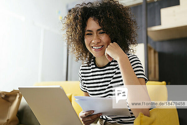 Happy businesswoman using tablet PC sitting at table
