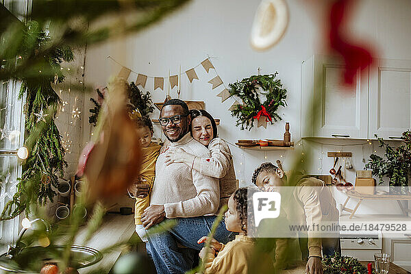 Happy family embracing each other and enjoying in kitchen at Christmas
