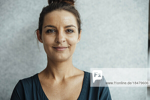 Smiling businesswoman in front of wall at home office