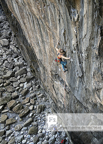 Active woman climbing on rocky wall