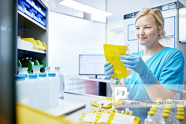 Frau hält wissenschaftliche Probe in einem mikrobiologischen Labor