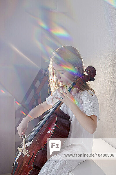 Girl playing cello at home