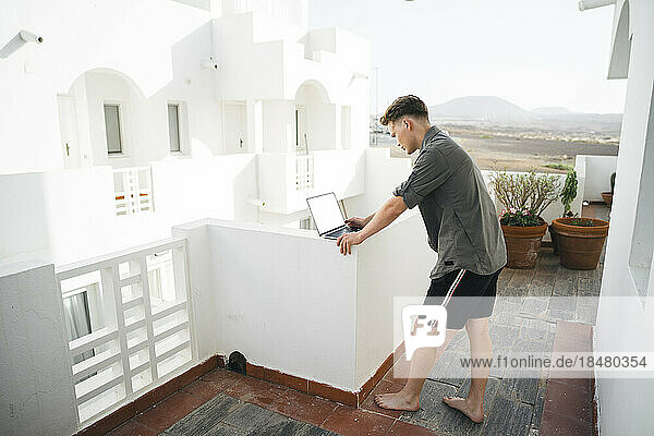 Freiberufler arbeitet am Laptop auf dem Balkon