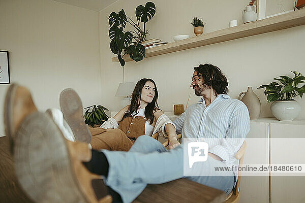 Couple with feet up sitting at home