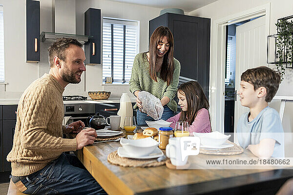 Glückliche Familie beim gemeinsamen Frühstück am Tisch in der Küche
