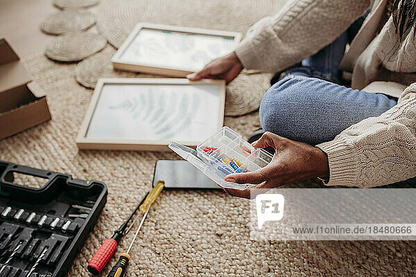 Woman making DIY picture frames sitting at home