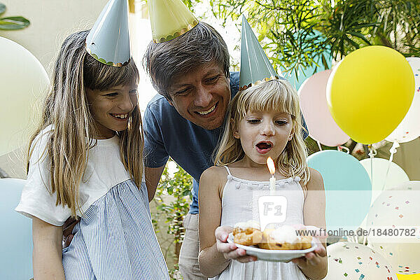 Glückliche Mädchen mit Vater  der Geburtstag im Garten feiert